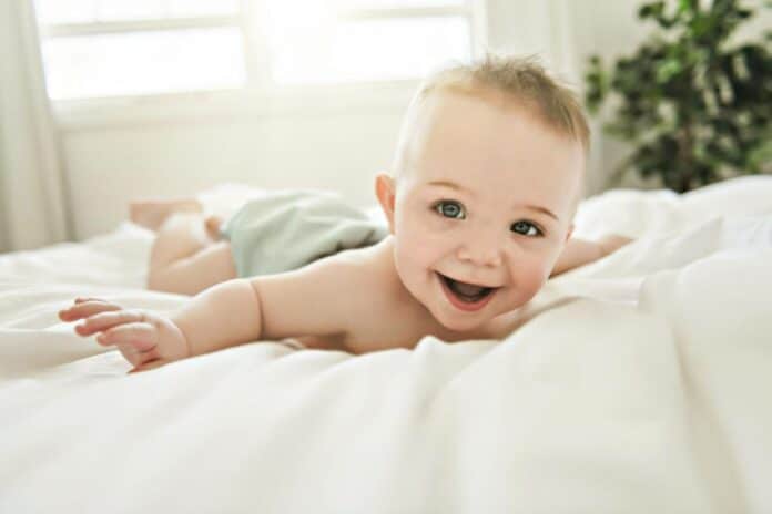 bébé joyeux sur le lit